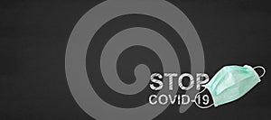 Medical mask with stop covid-19 text on a blackboard, covid-19, Coronavirus concept