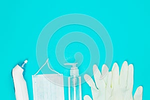 Medical mask, thermometer, white latex gloves and hand sanitizer gel on blue background.