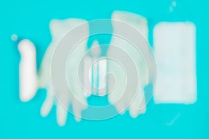 Medical mask, thermometer, white latex gloves and hand sanitizer gel on blue blurred background.
