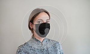 A medical mask on a woman `s face. Black mask to protect against bacteria, dust and viruses