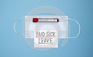 Medical mask with the words paid sick leave on a blue background