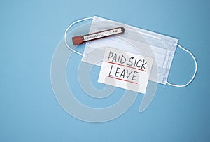 Medical mask with the words paid sick leave on a blue background