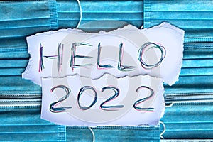The medical masks have paper with the words hello 2022 on them.