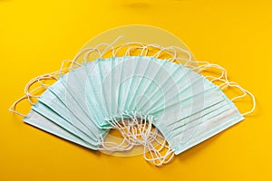Medical masks are laid out on a yellow background.