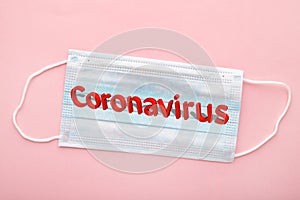 Medical masks on a pink background with copy space. The inscription Coronavirus