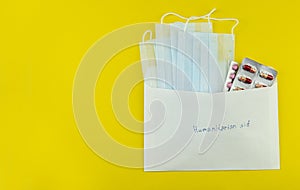 medical masks and tablets in a white envelope on a yellow background, isolates,