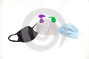 Medical masks of white and black color with vials of antiseptics for protection against viral infection isolated on a white backgr