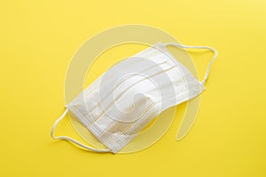 Medical masks of white color on yelliw background for protection against flu and other diseases. Surgical protective mask. Medical