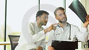 Medical multiethnic staff having discussion in a hospital. Indian and caucasian doctors discussing on the results of the
