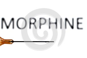 A medical needle with a droplet suspended refracting the word morphine, which is also out of focus in the background