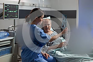 Medical nurse analyzing senior patient x-ray in hospital room