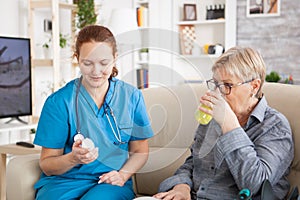 Medical nurse helping senior woman in nursing home