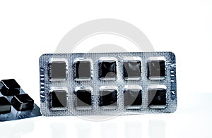 Medical pastille for relief cough, sore throat and throat irritation isolated on white background. Cough and colds drop. Black