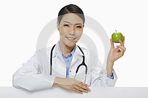 Medical personnel holding a green apple