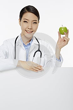 Medical personnel holding a green apple
