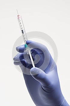 Medical personnel holding syringe, vertical