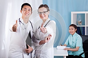 Medical personnel showing thumbs up sign photo