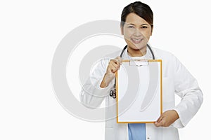 Medical personnel smiling and holding up a blank clipboard