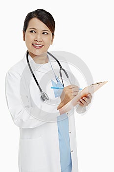 Medical personnel writing down notes on clip board