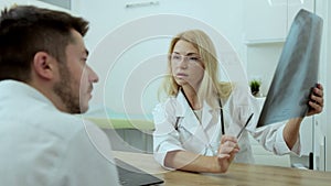 Medical physician doctor specialist showing x-ray image of lungs to patient explaining symptoms working at modern