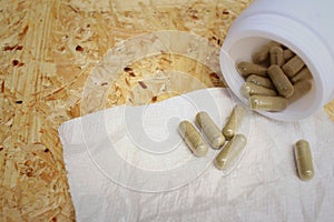 Medical pill on background of wooden table.