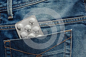 Medical pill blister at jeans pocket,  opaque blister pack of pills in jeans pocket