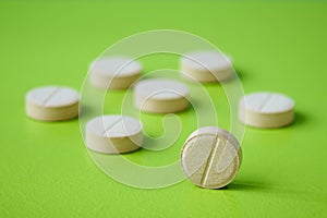 Medical pill closeup on green background. Medical drugs pills. Healthcare, pharmaceuticals and chemistry concept, shallow depth of