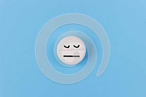 Medical pill with a sleeping face on a blue background. The concept of sleeping pills for insomnia
