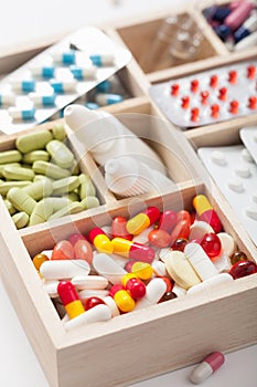Medical pills and ampules in wooden box