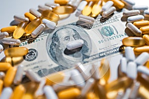 Medical pills lying on top of US Dollar Bill. Big pharma conspiracy theory