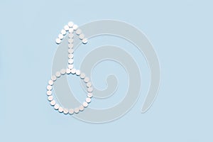 Medical pills in male symbol shape on a light blue background. Concept fmale health, contraception, fertility.