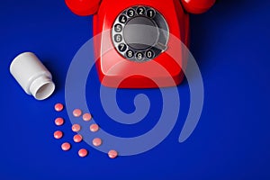 Medical pills and red telephone blue background