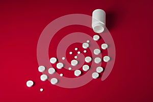 Medical pills round shape and bright bottle red background