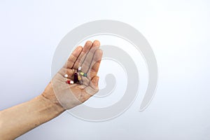 Medical pills such Ibuprofen or aspirin in a hand, white background