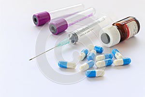 Medical pills and syringes on white table