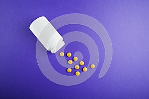 Medical pills vitamins on a colored background with a vial