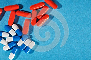 Medical pills white-blue and red on a bright background