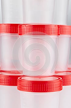 Medical plastic container for the collection of tests on the background of other containers, exhibited in several tiers