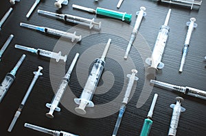 Medical syringes on dark wood board.