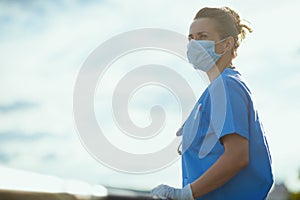 Medical practitioner woman outside in city against sky