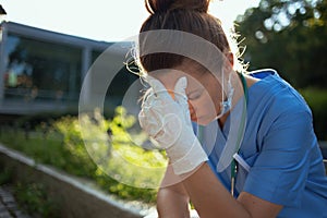 Medical practitioner woman sitting outdoors near hospital