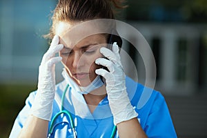 Medical practitioner woman using smartphone outside near clinic