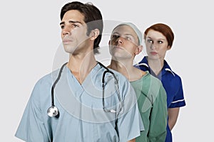 Medical practitioners standing together against gray background