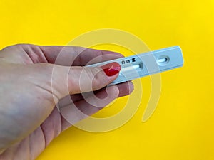 Medical procedures. coronavirus test on a bright yellow background. new home self-diagnosis kit. girl with bright red manicure