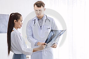 Medical professionals caucasian man holding xray and conversation