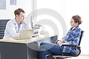 Medical professionals Caucasian man reassuring and talking with young woman stress patient.