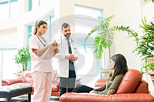 Medical Professionals Communicating With Woman At Hospital photo