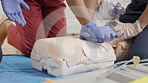 Medical professionals performing first aid procedure on mannequin