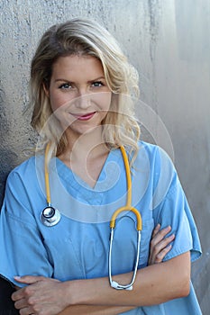 Medical professionals: Woman nurse smiling while working at hospital. Young beautiful blond caucasian female health care worker