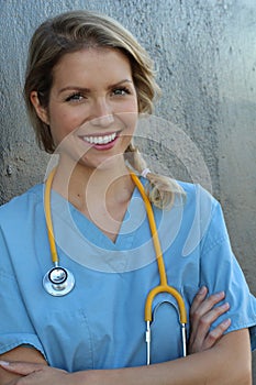 Medical professionals: Woman nurse smiling while working at hospital. Young beautiful blond caucasian female health care worker